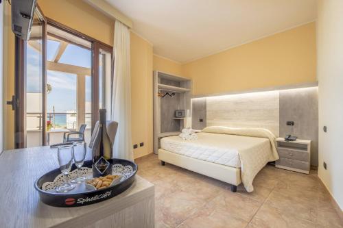 托雷圣乔万尼乌萨兰托米尔弗朗酒店的一间卧室,配有一张床和一碗桌上的食物