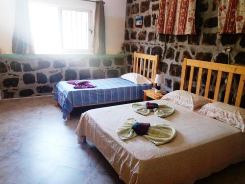 Cidade VelhaPousada Villa Concetta的客房设有两张床和窗户。