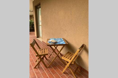 科莫Lario Promenade: family friendly apartment in Como的天井上摆放着一张桌子和两把椅子