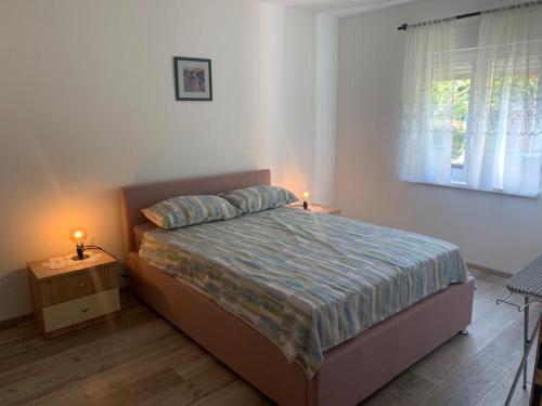温克兰Apartman Dalija的一间卧室配有一张床,床头柜上配有两盏灯