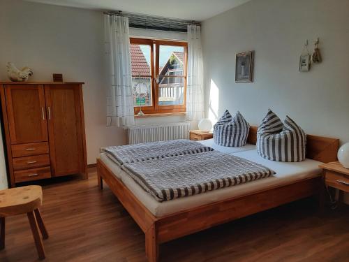 吕本瑙Auf "Kleine Wiesen"的卧室配有带枕头的床铺和窗户。