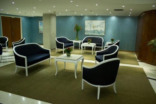 加拉加斯Hotel Chacao Cumberland的一间设有蓝色椅子和桌子的等候室