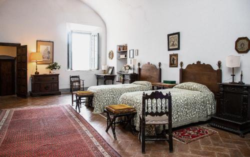 福斯迪诺沃Castello Malaspina di Fosdinovo的一间卧室配有两张床和一张桌子及椅子