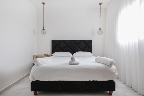 埃拉特By Eezy - צופית דירות אירוח的白色卧室配有白色大床和白色枕头