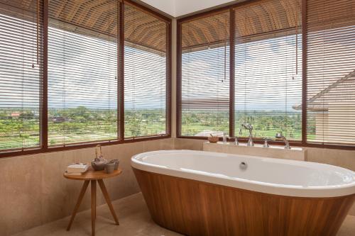 克拉玛斯凯拉玛斯海滩科马内卡度假村的窗户前设有大浴缸的浴室