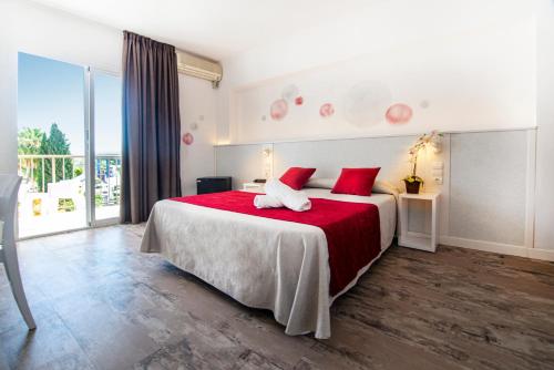 圣安东尼奥Hotel Tarba的一间卧室配有一张带红色枕头的大床