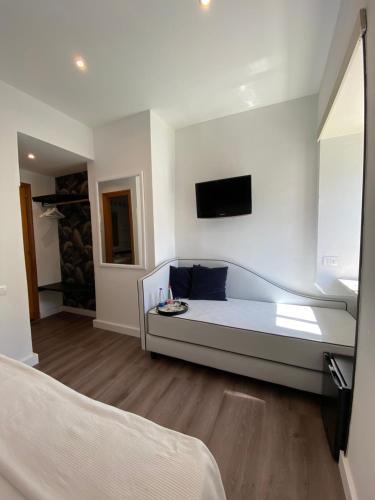 那不勒斯那不勒斯欧洲酒店的白色的客房设有沙发和墙上的电视