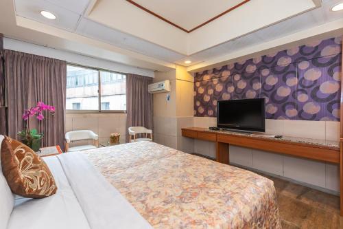 桃园市  一品商務飯店的配有一张床和一台平面电视的酒店客房