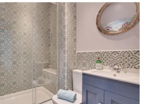 惠特比Silverwood Apartment, Whitby的浴室配有盥洗盆、镜子和浴缸