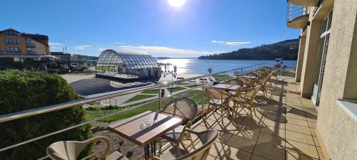 纳梅斯托沃Port Club pension & restaurant的阳台配有椅子,享有水景