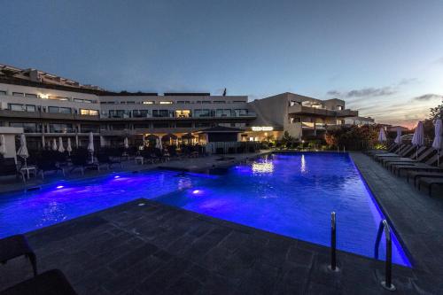 波尔蒂乔波提西欧套房酒店的夜间大型游泳池,灯光蓝色