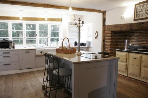 CrowhurstChurch Farmhouse, Surrey, Sleeps 10, Large Garden的一间厨房,配有白色的橱柜和一个大岛