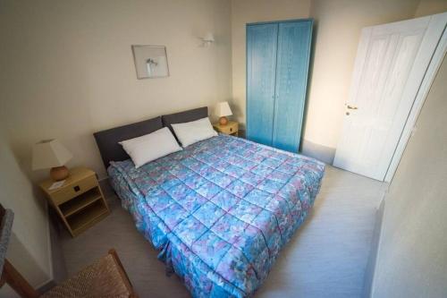 帕拉迪索海岸Casa del Tramonto Costa Paradiso的一间卧室配有一张带蓝色棉被的床