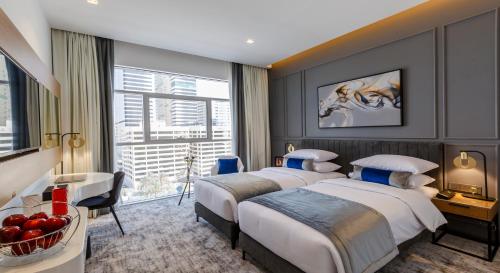迪拜Rose Executive Hotel - DWTC的酒店客房设有两张床和窗户。