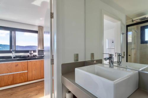 阿拉亚尔-杜卡布Ioda Guesthouse的白色的浴室设有水槽和大窗户
