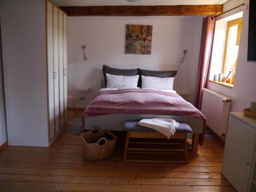 伊尔森堡"Heckenrose"的一间卧室配有一张带红色毯子的床和窗户。
