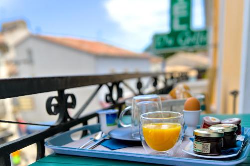 巴拉吕克莱班Hôtel du Golfe Sete-Balaruc的桌上装有一杯橙汁的托盘
