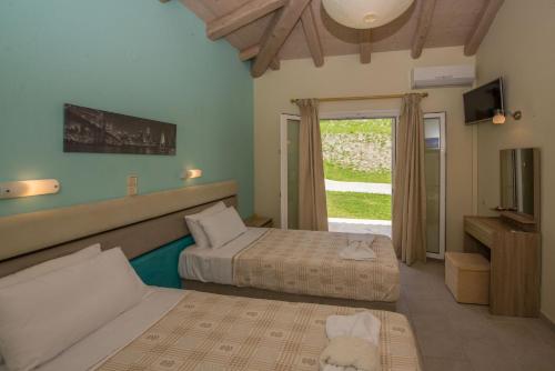 埃费奥纳斯Villas Porto Kamini Afionas Corfu的酒店客房设有两张床和窗户。