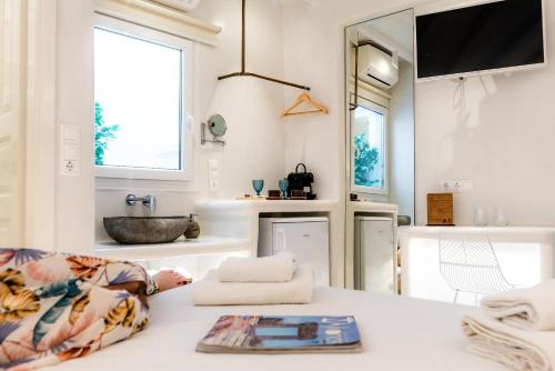 米克诺斯城Anastasia's Visage Stylish Accommodation Rooms City Centre Mykonos的客厅配有水槽和桌子