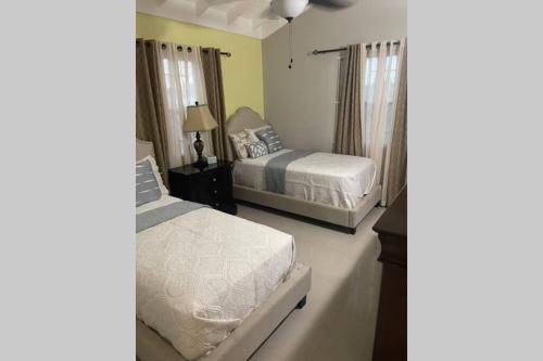 曼米湾Villa Kalaya的一间卧室设有两张床和一张桌子上的台灯。