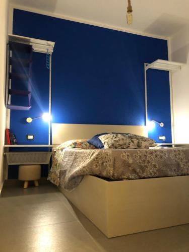 斯卡莱阿La Pedrosa 83的一间拥有蓝色墙壁的卧室和一张带两个灯的床