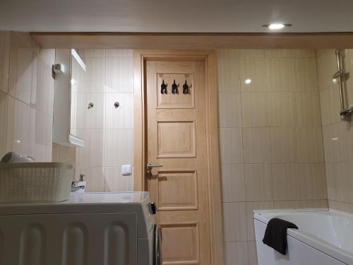 文茨皮尔斯KK Apartment city的浴室设有门、水槽和浴缸。