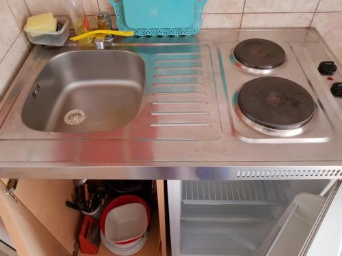 乌尔齐尼Guesthouse Domenik的厨房柜台设有水槽和炉灶。