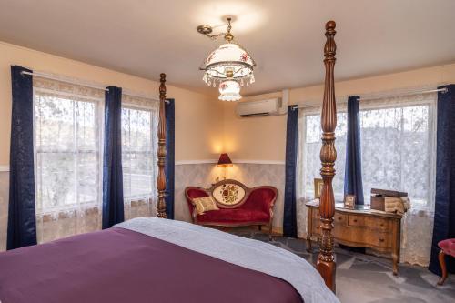罗斯堡HISTORICAL JOHN RAST HOUSE circa 1875的一间卧室配有一张床、一把椅子和窗户。