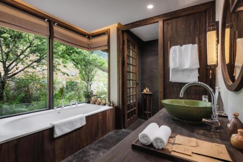 枚州县Avana Retreat的一间带大浴缸和大窗户的浴室