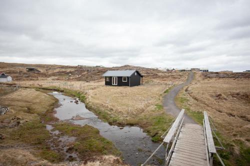 托尔斯港Luxury Cottage in Tórshavn的山丘上一条路的黑色小房子