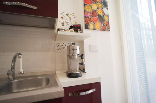 丽都迪奥斯蒂亚Appartamento Piazza Anco Marzio的厨房配有水槽和台面上的搅拌机