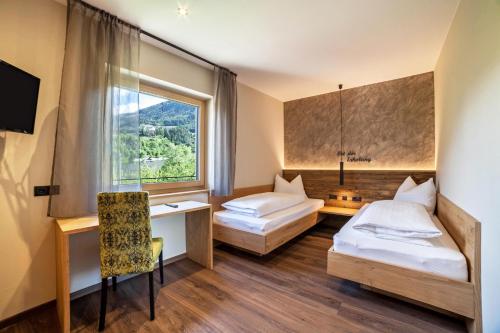 梅拉诺Ferienwohnung Pinot的酒店客房设有两张床和窗户。