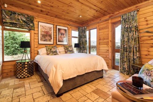 阿马Castledillon Forest Lodge的卧室配有一张床铺,位于带木墙的房间内