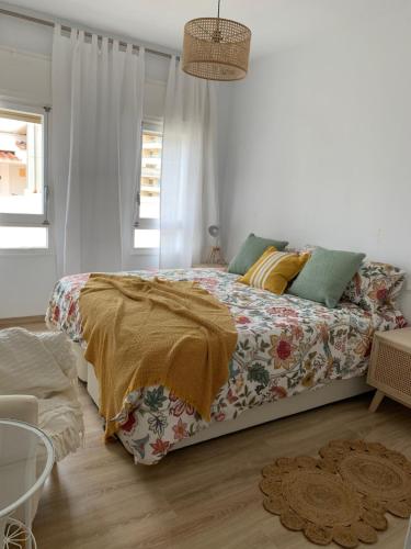 多列毛利诺斯PERLA DEL SOL的一间卧室配有一张带花卉床罩的床