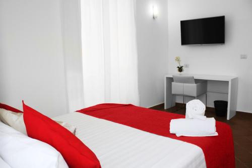 罗马罗马圆形大剧场度假公寓式酒店的卧室配有红色和白色的床和电视。