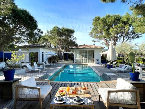 波尔蒂乔Les Suites d'Agosta的庭院设有游泳池、椅子和水果桌。