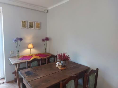 卡齐米日-多尔尼维托旅馆的一间用餐室,配有两把桌子和椅子,并种植了紫色的鲜花