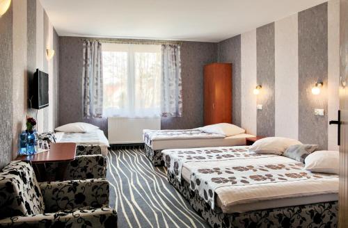 斯拉百斯宏达酒店的酒店客房设有三张床和窗户。