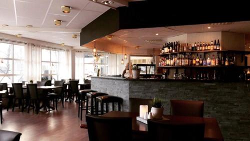 GrongGrong Hotell的一间带桌椅的餐厅和一间酒吧