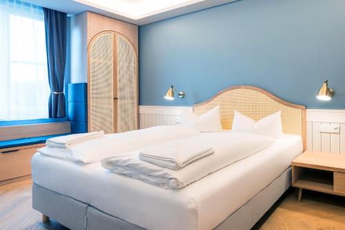 黑灵斯多夫黑灵斯多夫斯特尔酒店的卧室配有白色大床和蓝色的墙壁