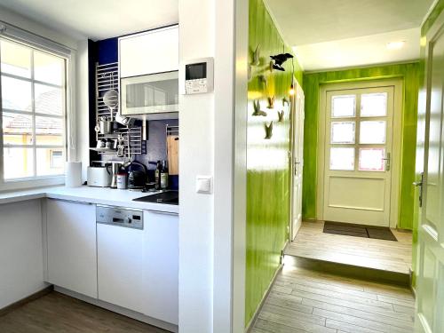 斯皮特安德劳Entzückende Garconniere im Herzen Spittals的厨房配有白色橱柜和绿色墙壁