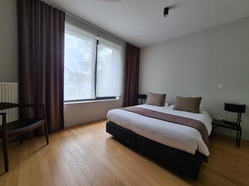布鲁塞尔五十周年纪念海岸住宿加早餐酒店的一间卧室设有一张床和一个大窗户