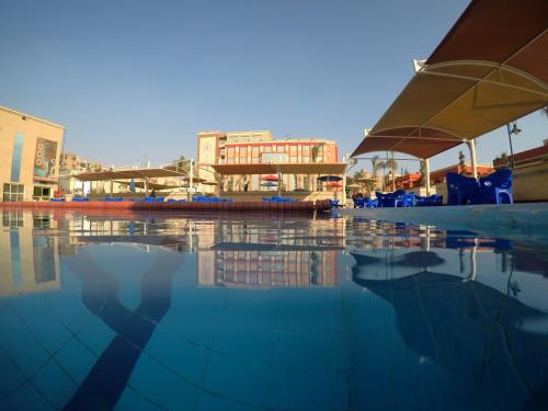 开罗Rehana Resort的一个带椅子和遮阳伞的水池