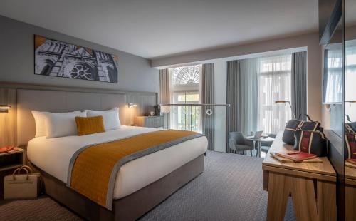 科克Maldron Hotel South Mall Cork City的酒店客房设有一张大床和一张书桌。