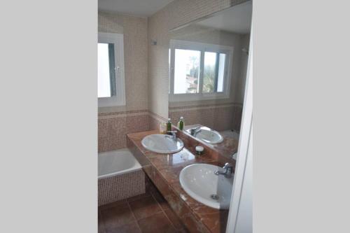 蓬塔格罗萨Villa Blanca Punta Grossa的浴室配有两个盥洗盆和浴缸。