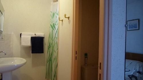 Le Brugeron玫瑰人生酒店的浴室配有盥洗盆、卫生间和盥洗盆。