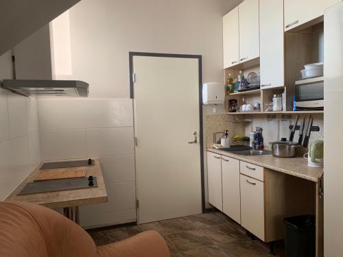 塔林Rotermanni hostel 4Floor NO LIFT的厨房配有白色橱柜和白色门