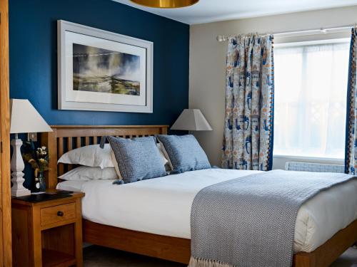 伊尔明斯特The Barrington Boar的一间卧室配有一张蓝色墙壁的床