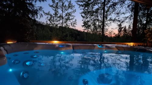 耶姆赛Villa Lumi 10 henkilölle, Himos Länsihuippu的晚上在后院的热水浴池
