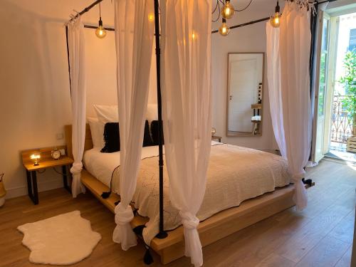阿维尼翁My Pad Provence 7的卧室配有带白色窗帘的天蓬床